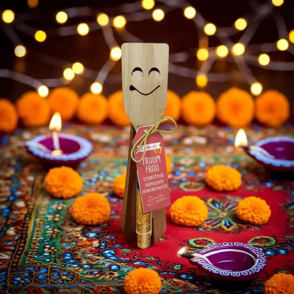 Lustiger Gewürzhalter mit Smiley-Gesicht und Etikett „Traumfrau“ auf orientalischer Tischdeko, umgeben von Lichtern und Blüten, feinkostgourmet Delikatessen Geschenkidee