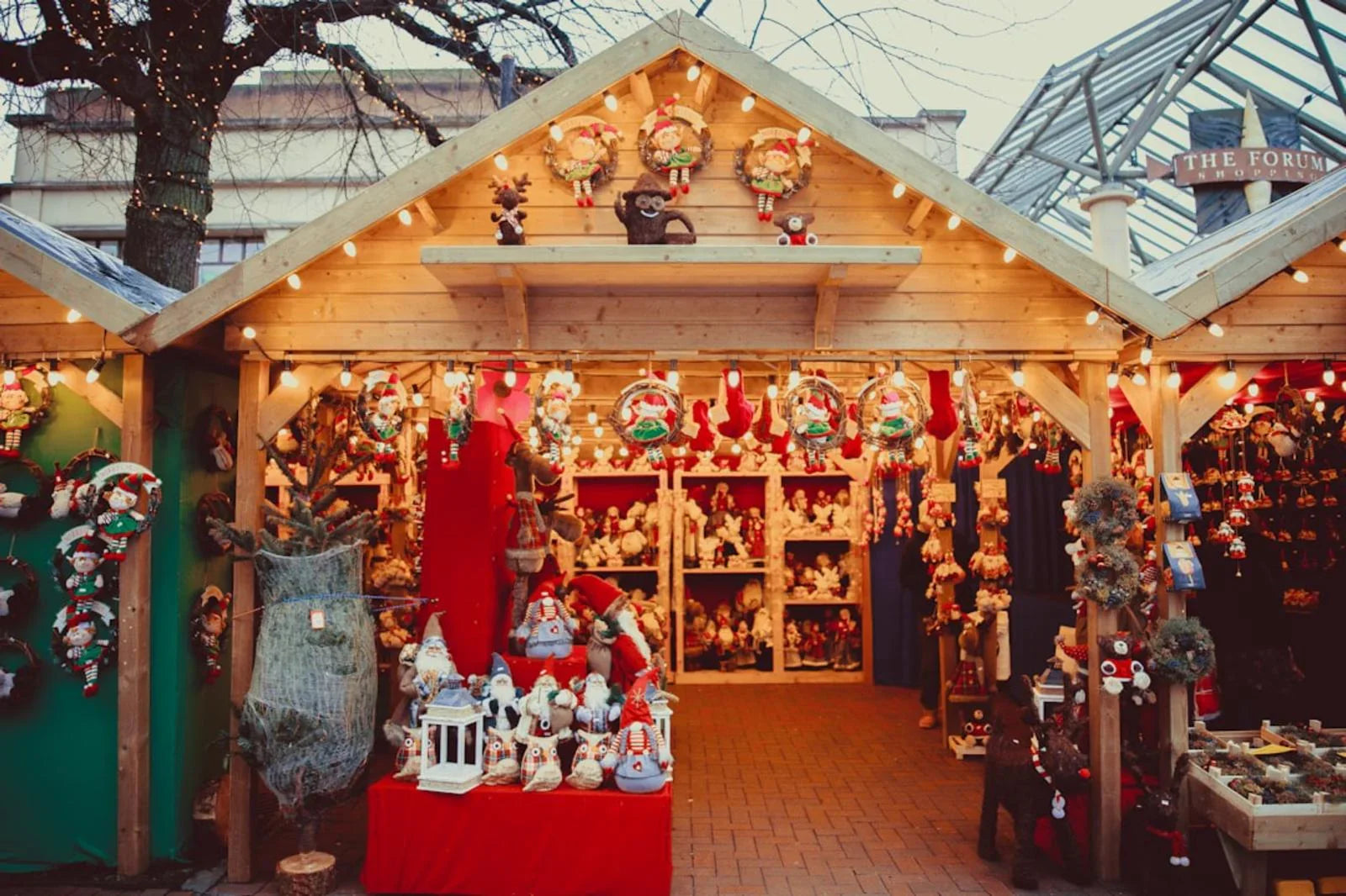 Weihnachtsmarkt Berlin, festlich geschmückter Stand mit Weihnachtsdeko, Kränzen und Lichtern
