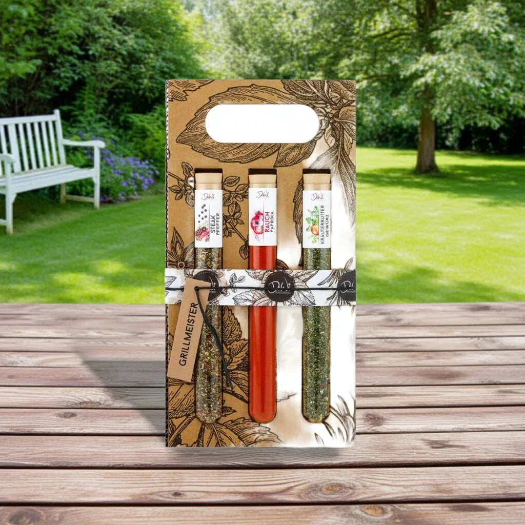 Grillmeister Geschenkset mit Premium BBQ Gewürzen von feinkostgourmet auf Holztisch im Garten