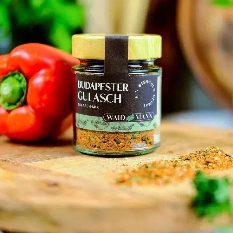 Budapester Gulasch-Gewürzmischung im Glas mit Paprika auf Holzbrett, feinkostgourmet Delikatessen